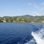 Vista panoramica della baia nascosta in Liguria, circondata da scogliere e acque cristalline.