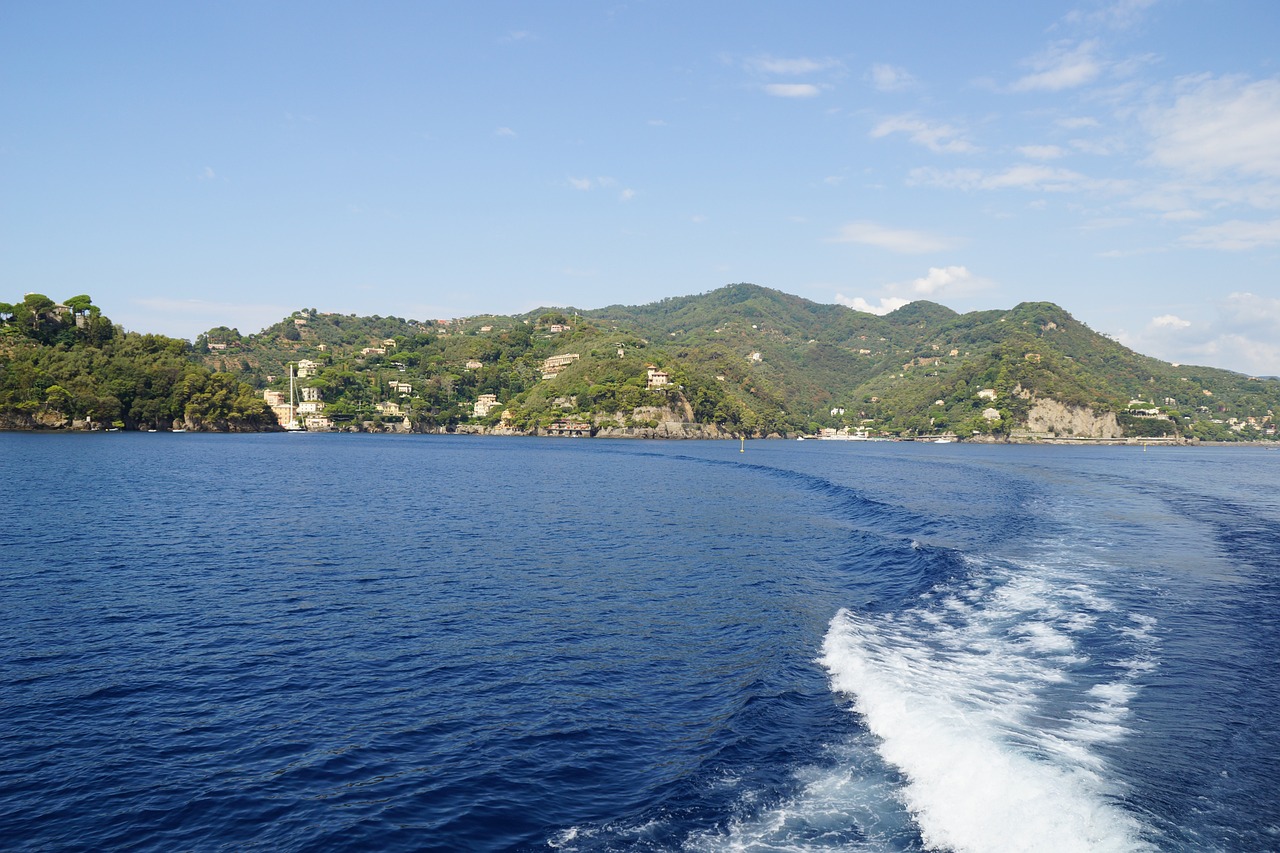 Vista panoramica della baia nascosta in Liguria, circondata da scogliere e acque cristalline.