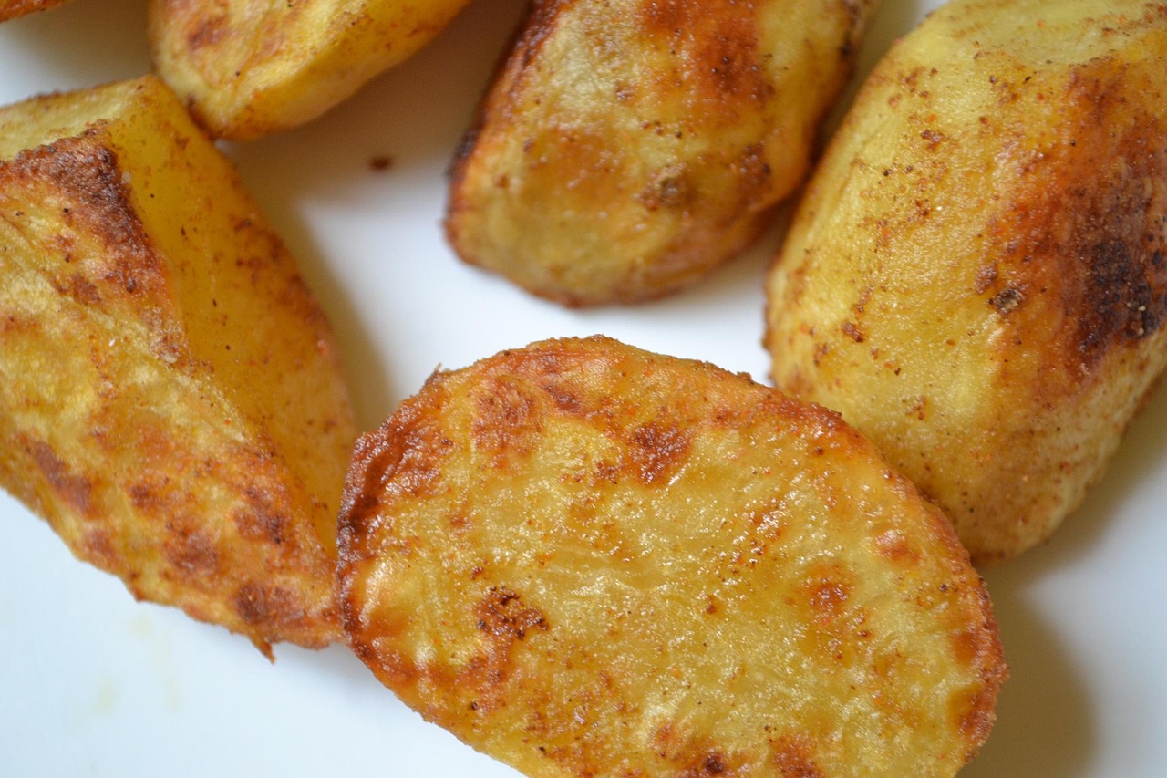 Patate al forno croccanti servite su un piatto, senza olio, pronte per essere gustate.
