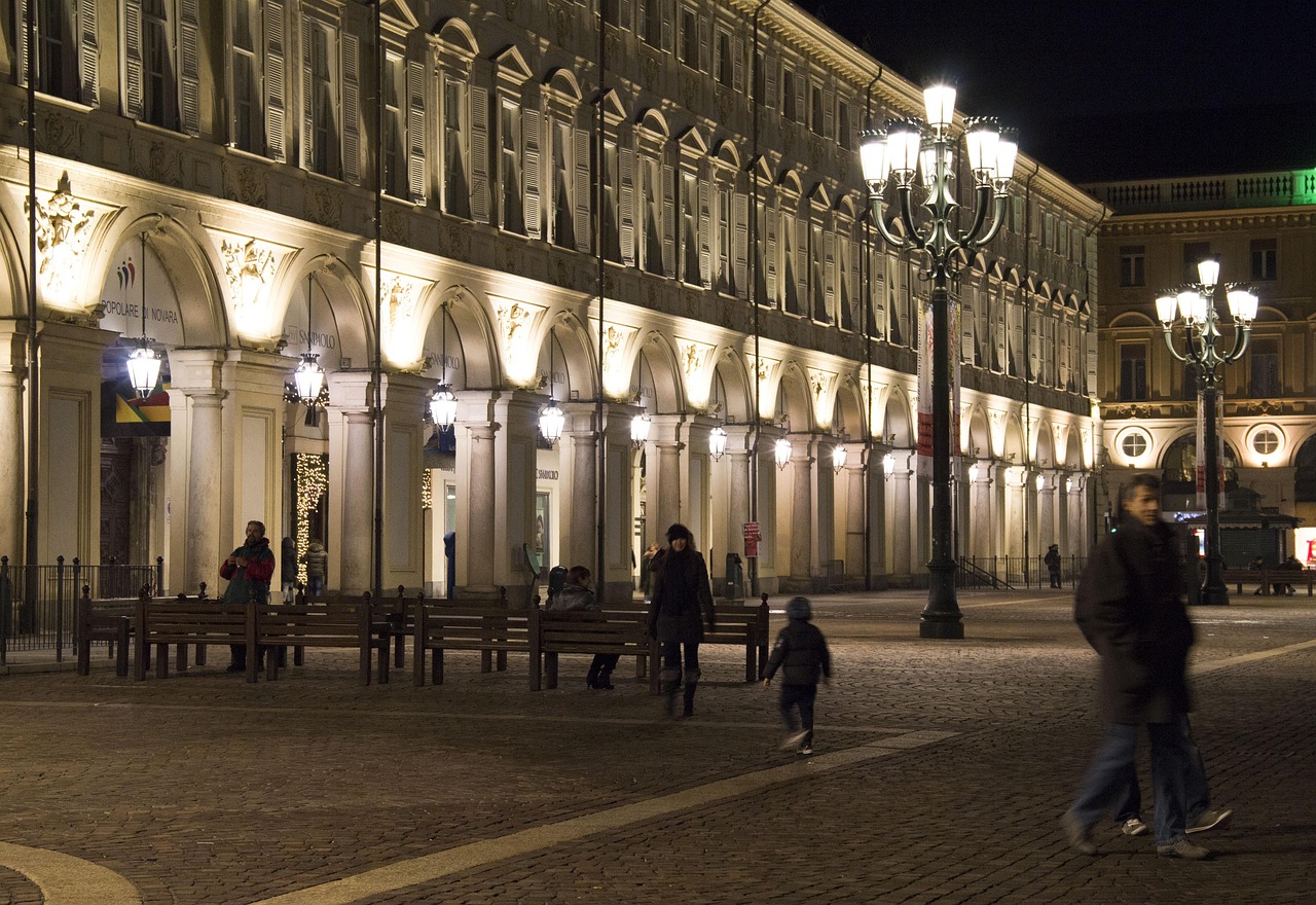 Illuminazioni natalizie spettacolari in una piazza italiana, evidenziando colori e forme artistiche.