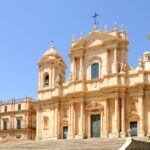 Dettaglio di un edificio barocco a Noto, evidenziando la sua facciata ornata e l'arte architettonica.