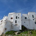 Veduta panoramica del suggestivo borgo pugliese con architetture tipiche e paesaggio da cartolina.