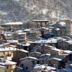 Borgo affascinante della Val d’Aosta, con case in pietra e montagne sullo sfondo.