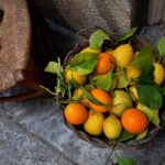 Mercato pugliese con bancarelle di agrumi freschi e clienti che li annusano al mattino.