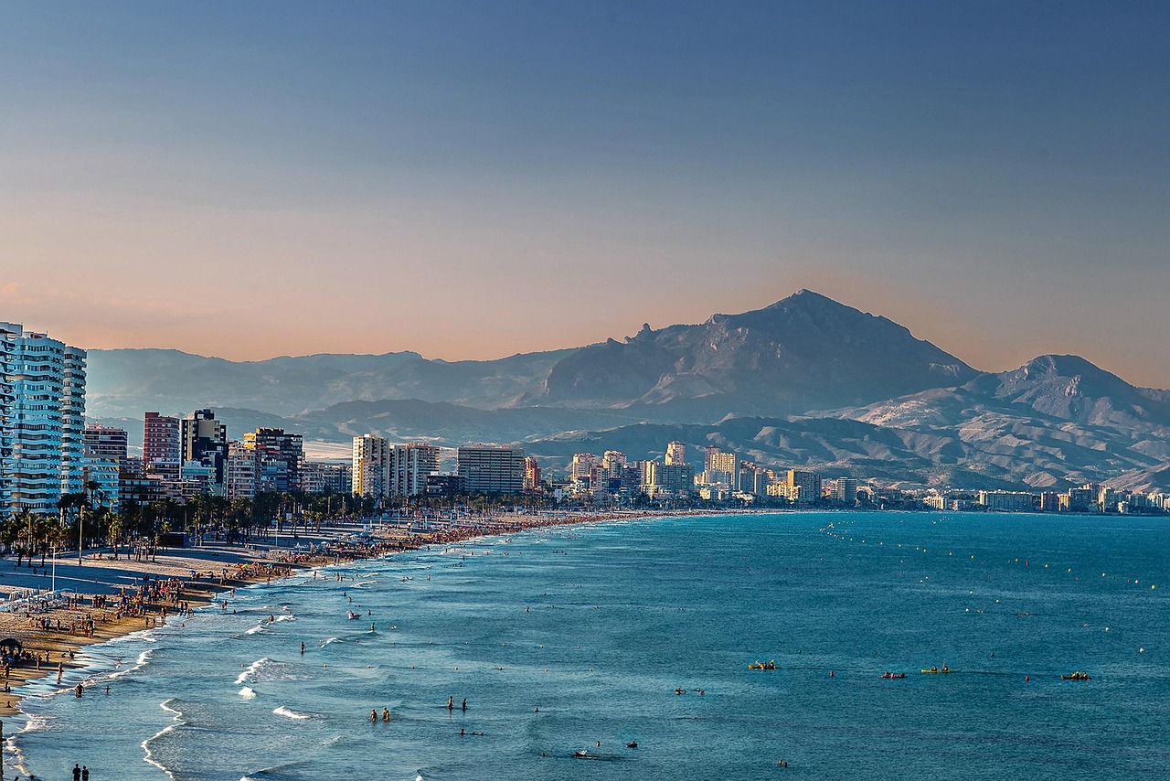 Spiaggia soleggiata con palme e mare turchese, simbolo delle località costiere spagnole.