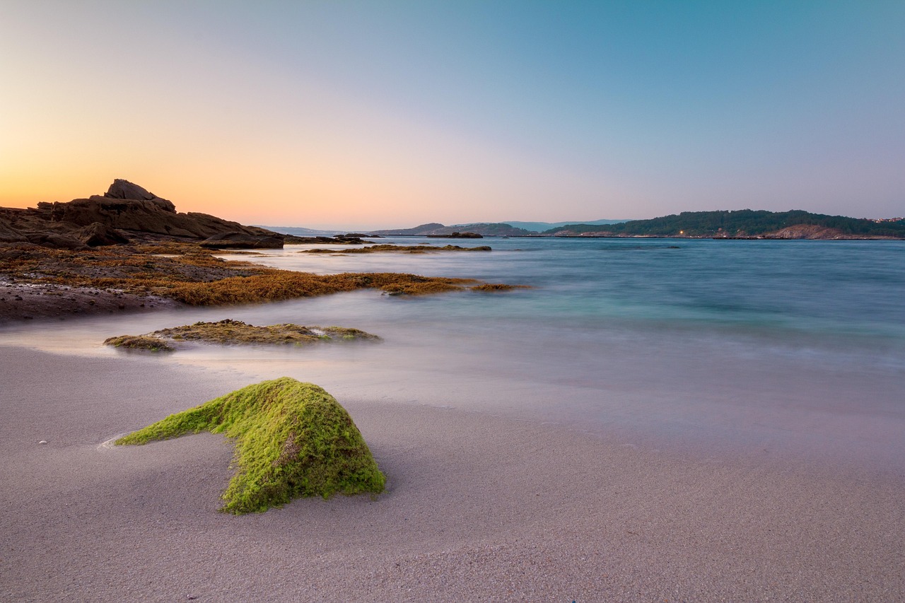 Spiaggia sarda all'alba, onde che brillano come diamanti sotto la luce del sole nascente.