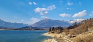 Lago incantevole del Friuli, circondato da montagne e vegetazione lussureggiante.