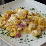 Tortellini serviti in una trattoria tipica di Bologna, con decorazioni tradizionali sullo sfondo.
