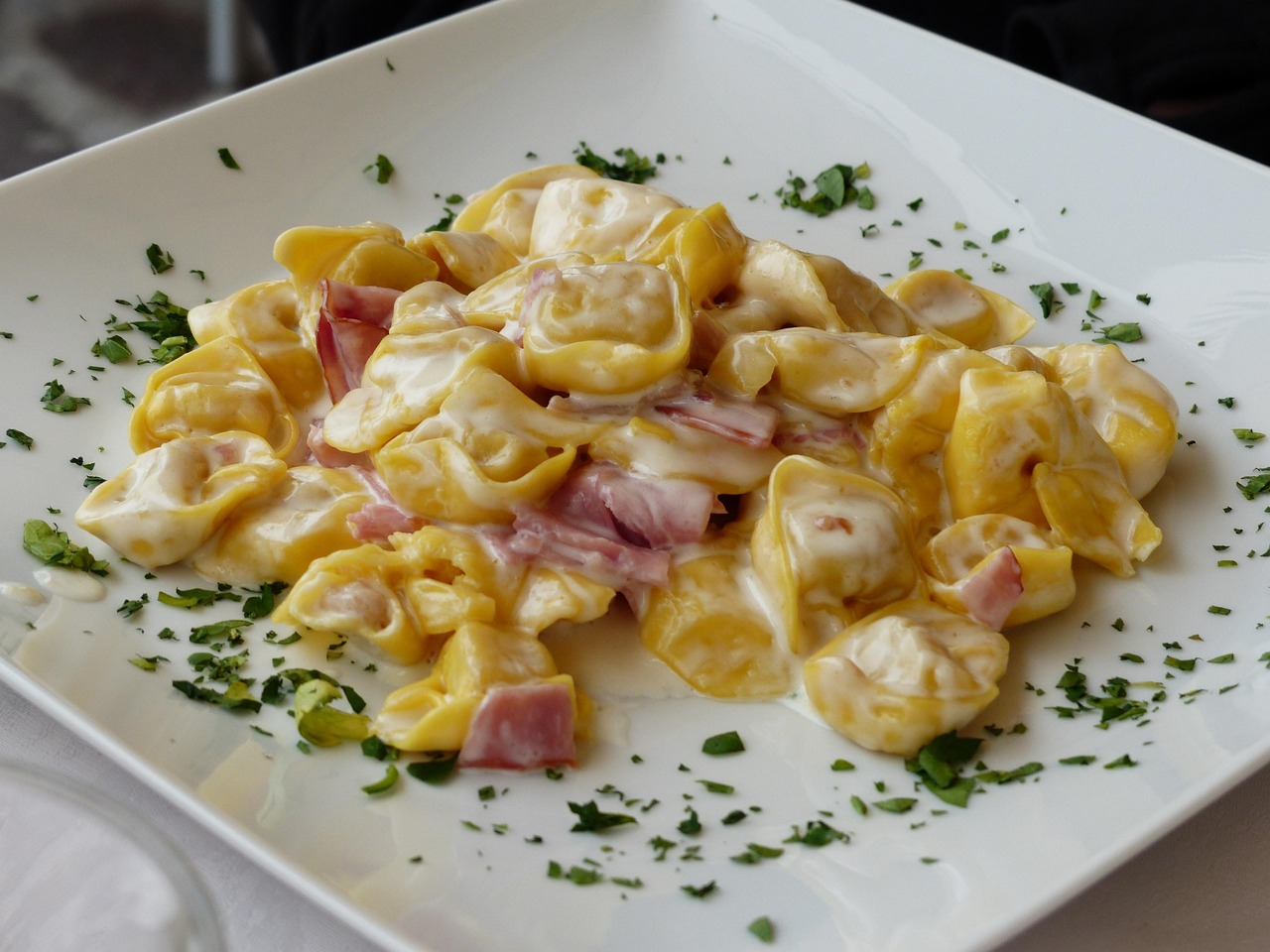 Tortellini serviti in una trattoria tipica di Bologna, con decorazioni tradizionali sullo sfondo.