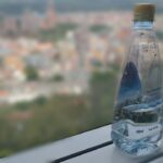 Immagine di bottiglie d'acqua con etichetta 'Bonus Acqua' per famiglie.