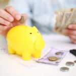 Libretto di risparmio con grafico di crescita e simboli di investimento.